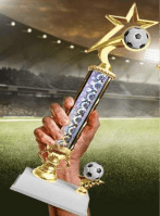 A person holding up a trophy with soccer balls on top of it.